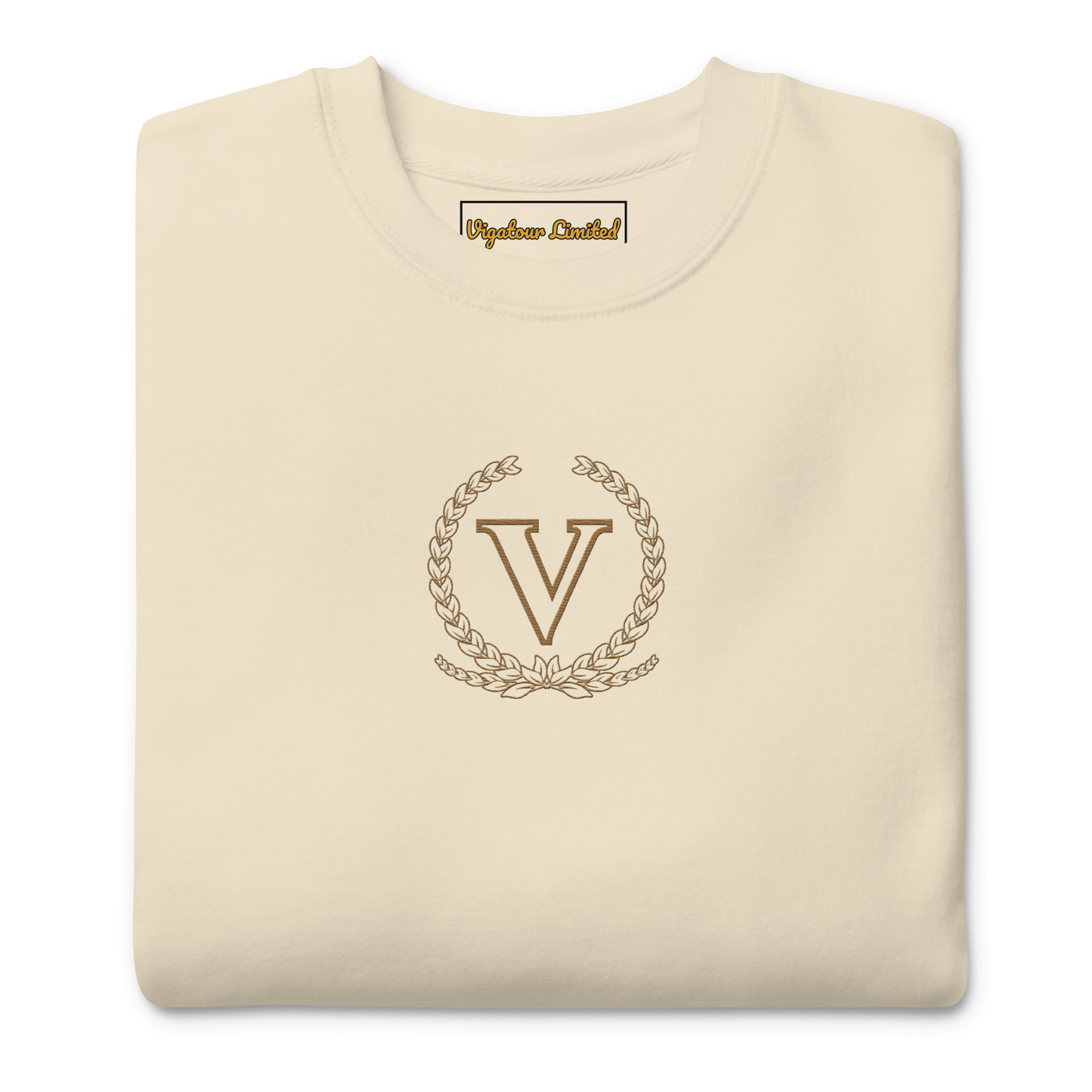 Folded beige sweatshirt with a gold emblem and 'V' letter on a white background