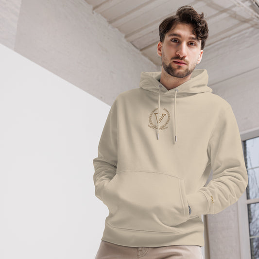 Man wearing a beige hoodie with a logo indoors
